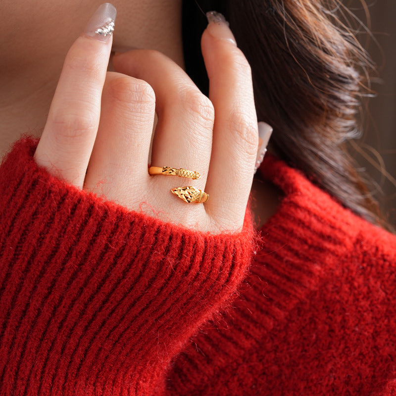Gold snake ring worn with red sweater and glitter nails