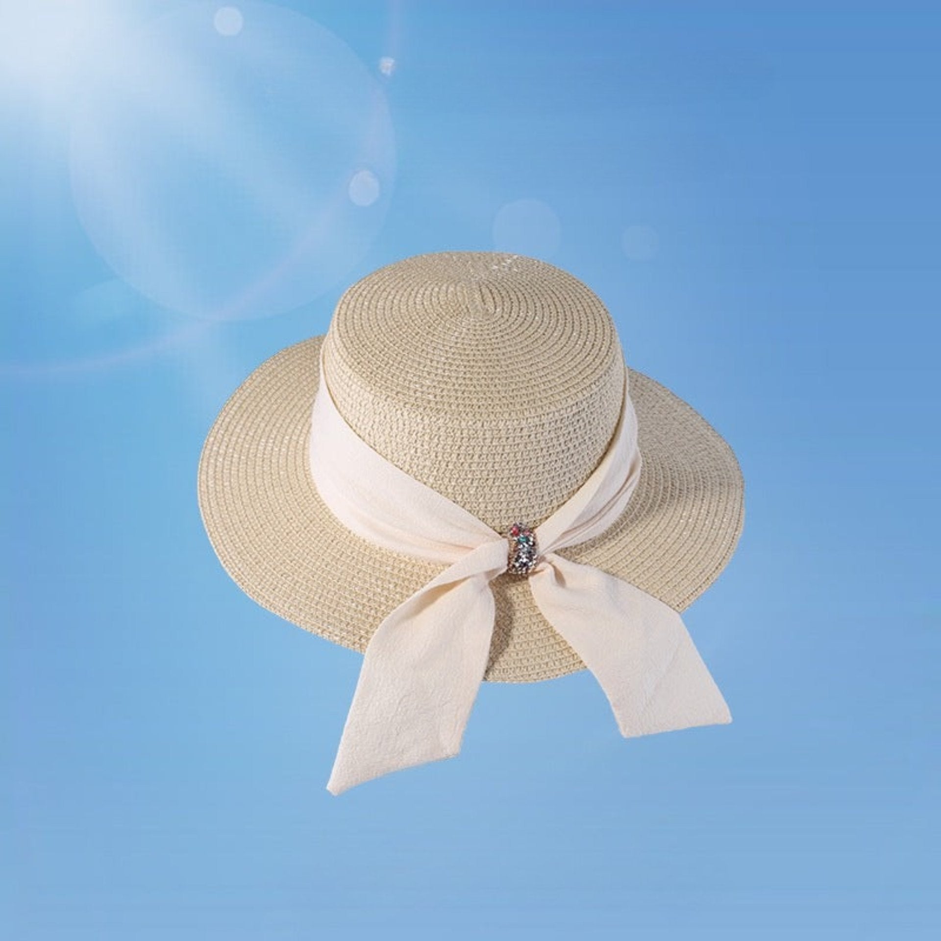 Beige women's wide brim straw hat with a stylish bowknot and crystal detail. A fashionable and functional sun hat for outdoor elegance.