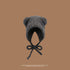A heather gray teddy bear ear bonnet with black ties displayed against brown background, showing rounded ear design and fluffy texture