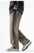 Gray wide-leg drawstring pants styled with a black varsity jacket and white sneakers