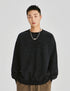 Unisex oversized sweatshirt in black with an embossed logo, soft washed fabric, and a relaxed streetwear silhouette