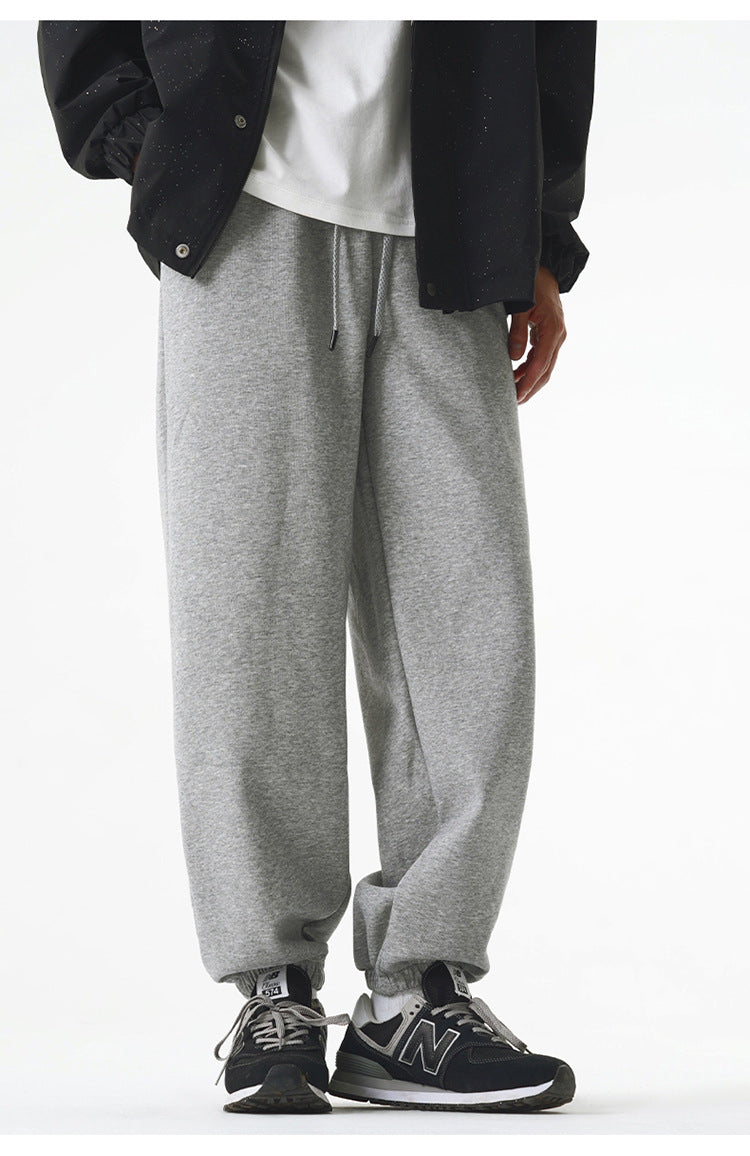 A model is wearing gray jogger sweatpants with a drawstring waistband and elastic cuffs