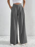 Charcoal gray pleated wide-leg trousers with angled waistband detail.