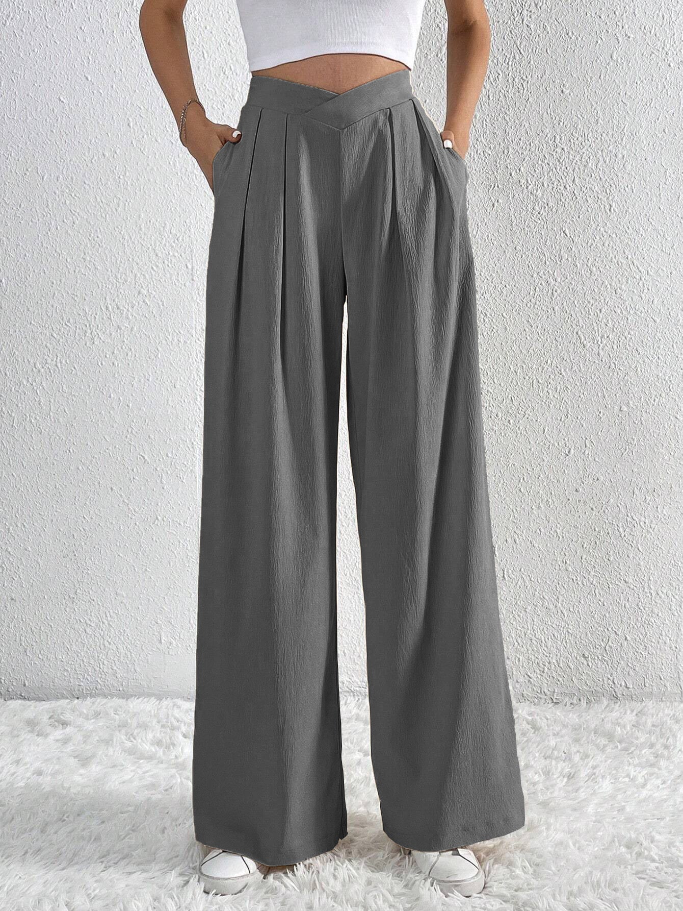 Charcoal gray pleated wide-leg trousers with angled waistband detail.