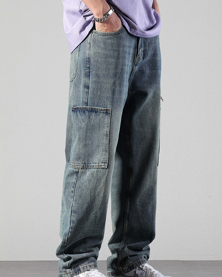 Side view of model with hand in pocket wearing washed denim cargo pants with large patch pockets, lavender tee and silver bracelet