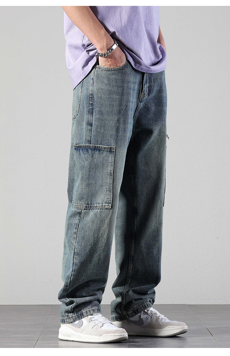 Side view of model with hand in pocket wearing washed denim cargo pants with large patch pockets, lavender tee and silver bracelet