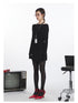 Black off-shoulder knit sweater with oversized fold-over neckline and cinched waist. Side view showing ID badge holder on lanyard.