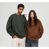 Two models posing against white background - one in olive textured sweatshirt with white pants, another in brown textured sweatshirt with denim culottes