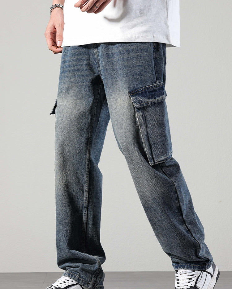 Side view of distressed blue denim cargo pants with side pockets and white/black sneakers