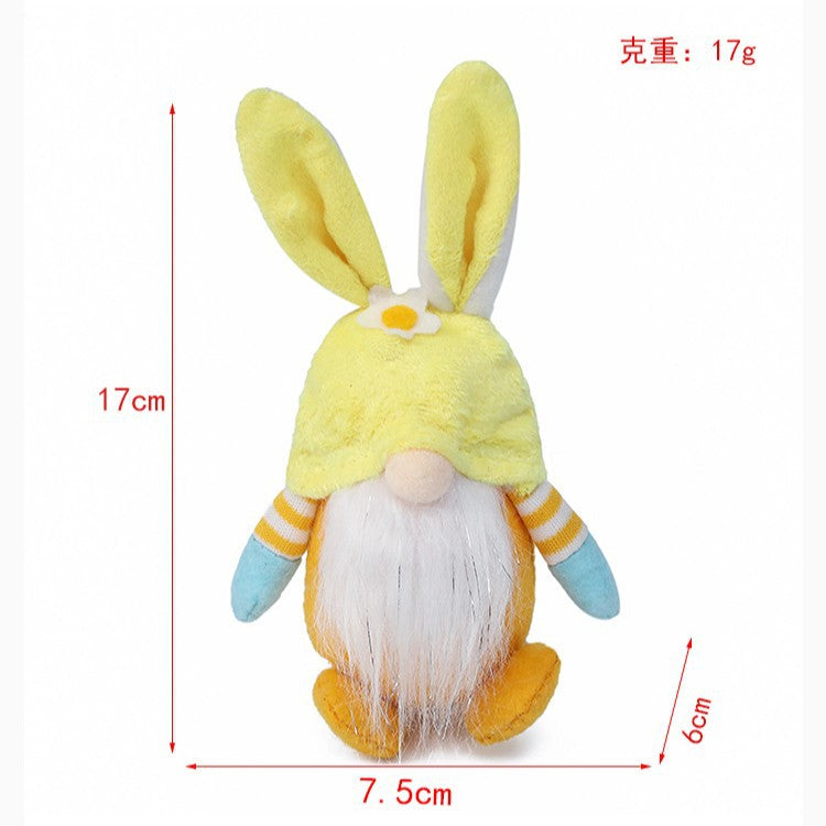 Yellow plush bunny gnome with flower detail, sitting upright. Dimensions: 17cm height, 7.5cm width, 6cm depth, weight 17g.