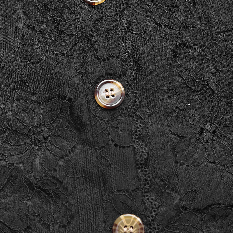 Close-up of tortoiseshell-style buttons on black lace fabric, emphasizing intricate details and craftsmanship.