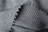 Close-up of V-neck ribbing construction, showing intersection of knit patterns.
