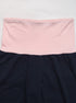 Detailed view of pink fold-over waistband on navy blue pants, showing the contrast color and smooth fabric.