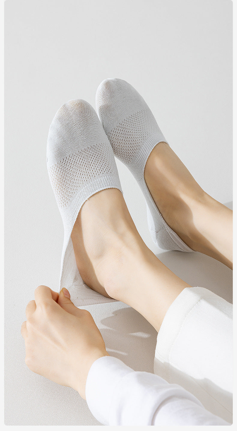 White no-show socks styled on feet against white background, demonstrating fit and coverage