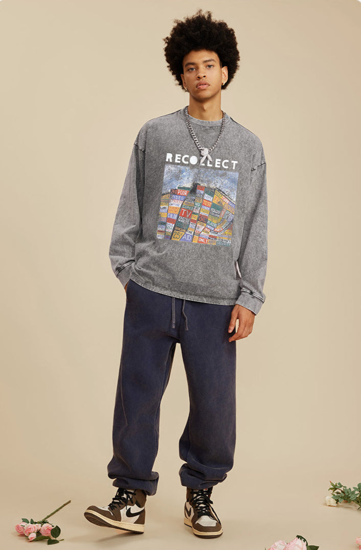 A male model wears a gray oversized "RECOLLECT" sweatshirt with a bold print, posing with hands in pockets