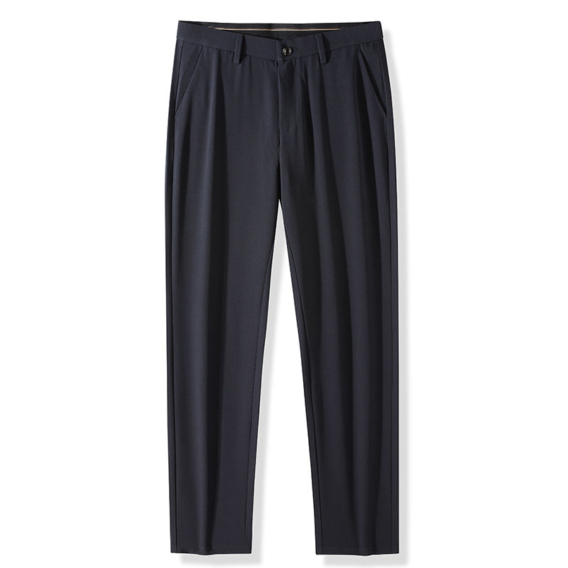 Navy blue pleated dress trousers with belt loops and front button closure on white background