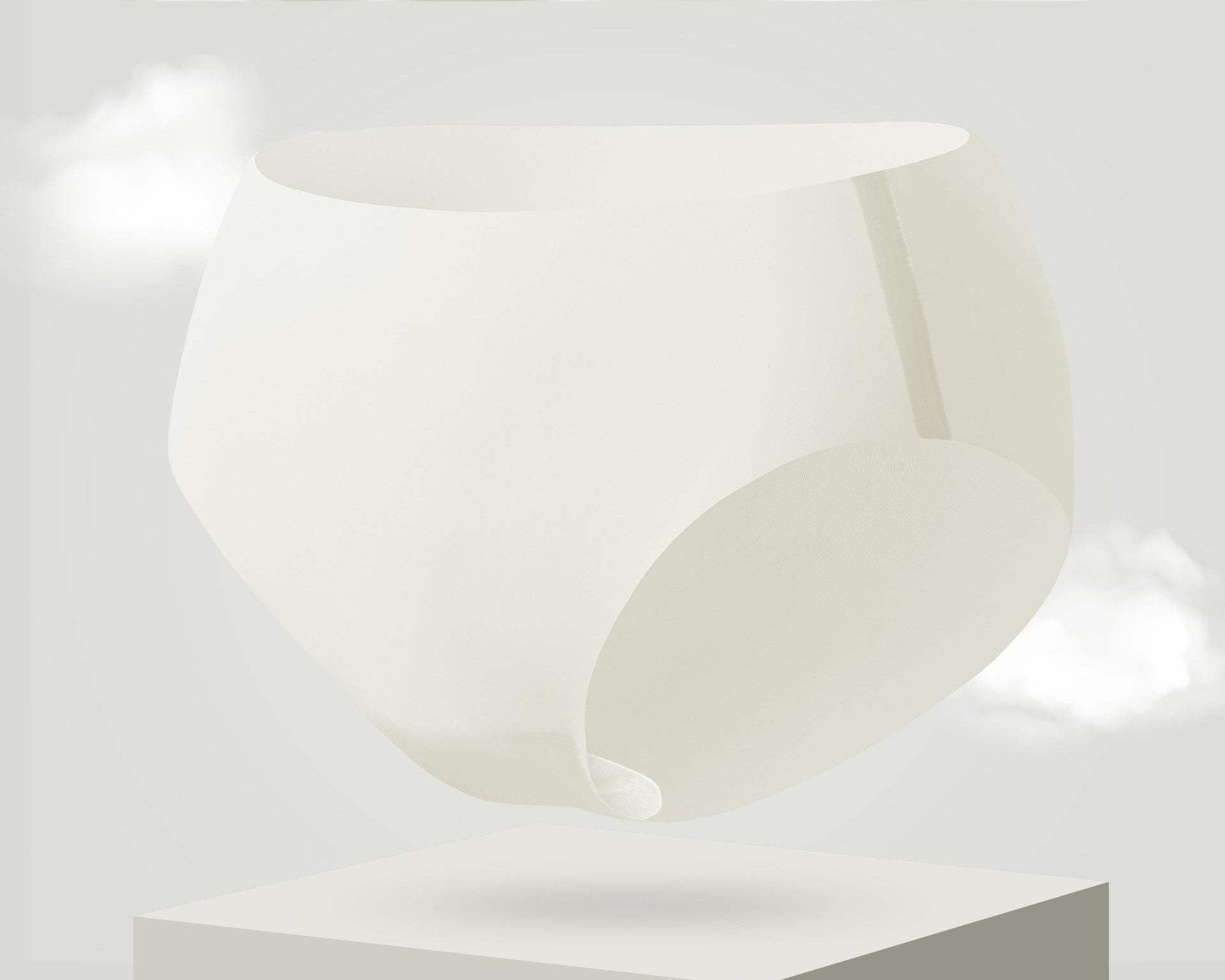 Ultra-thin cooling seamless brief in milky white color, floating above white pedestal with cloud effects in light gray background