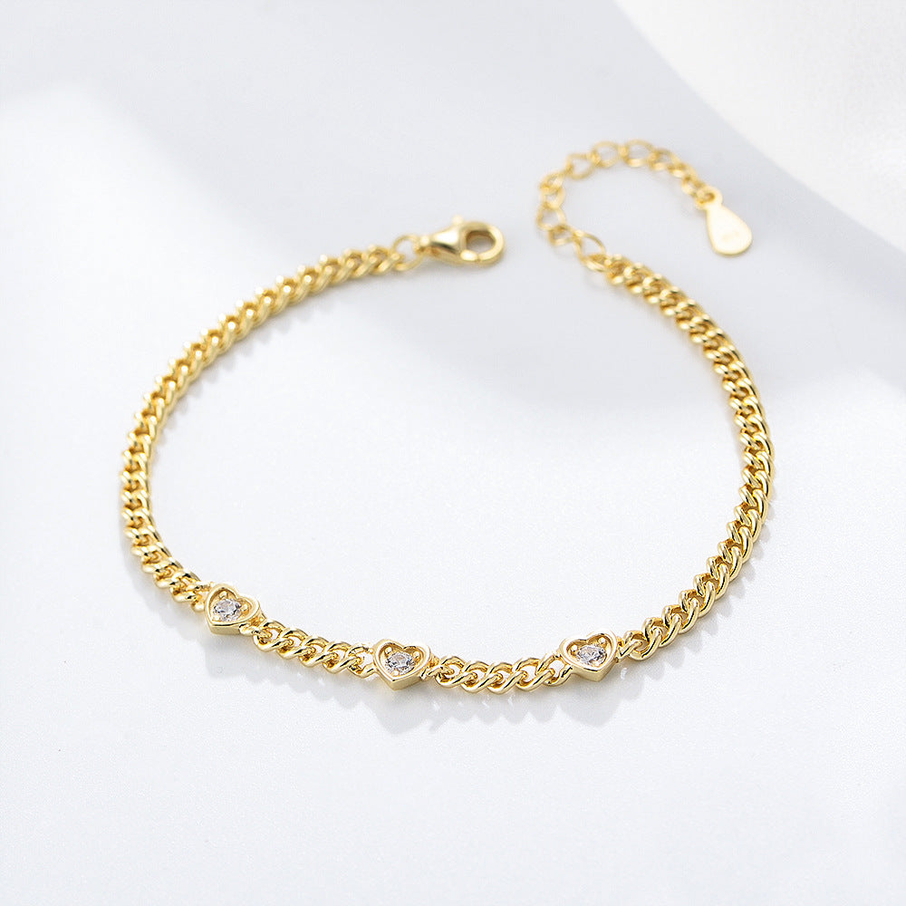 Gold chain bracelet with three small heart-shaped CZ charms.