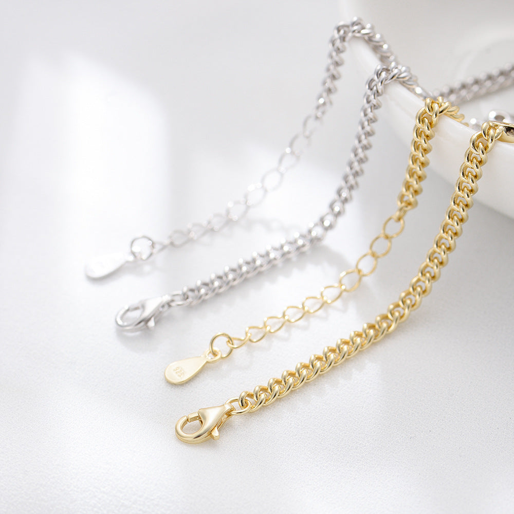 Close-up of gold and silver bracelet chains with lobster clasps and extender tags.