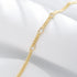 Close-up of gold bracelet on white fabric, highlighting heart-shaped CZ details.