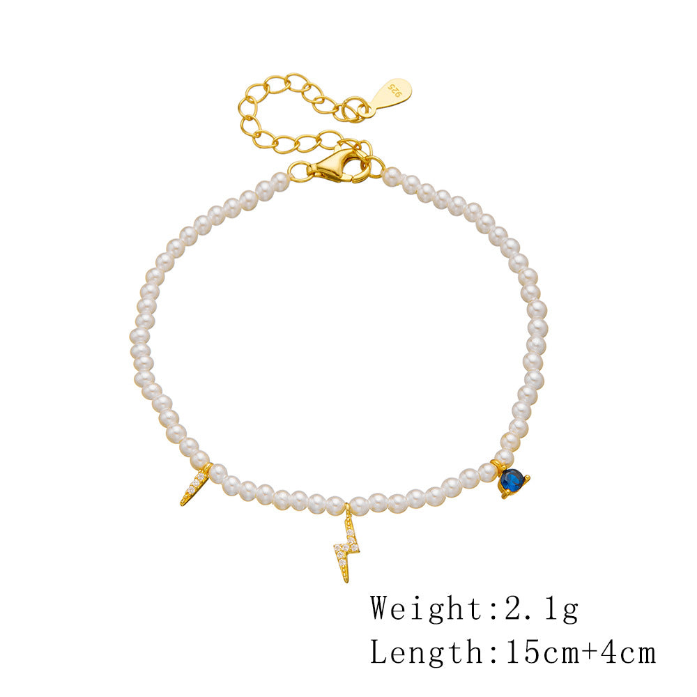 Product display of adjustable pearl bracelet with gold-plated lightning and heart charms, with measurements shown.