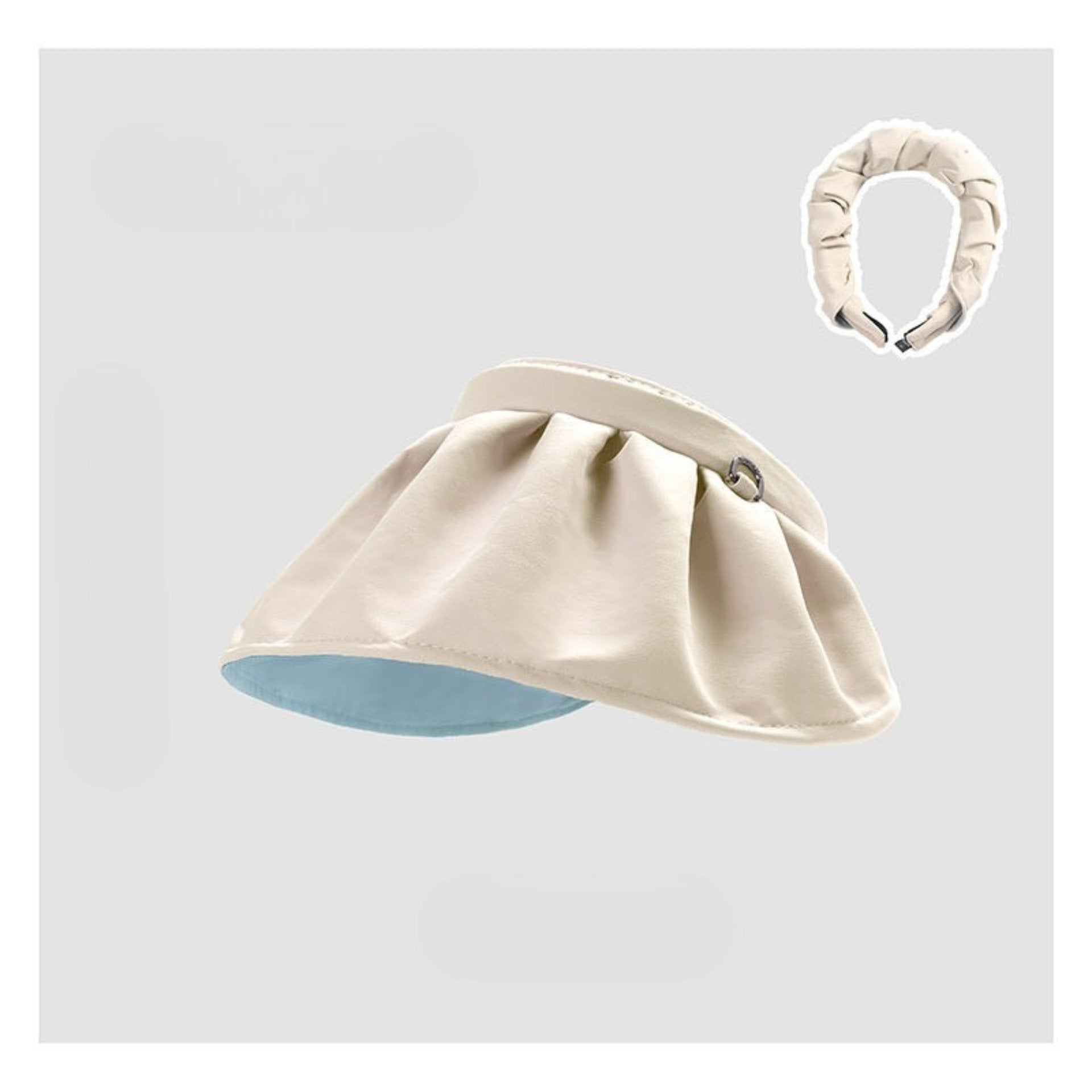A fashionable cream-colored shell hat with a reversible design, featuring a small loop detail on the side.