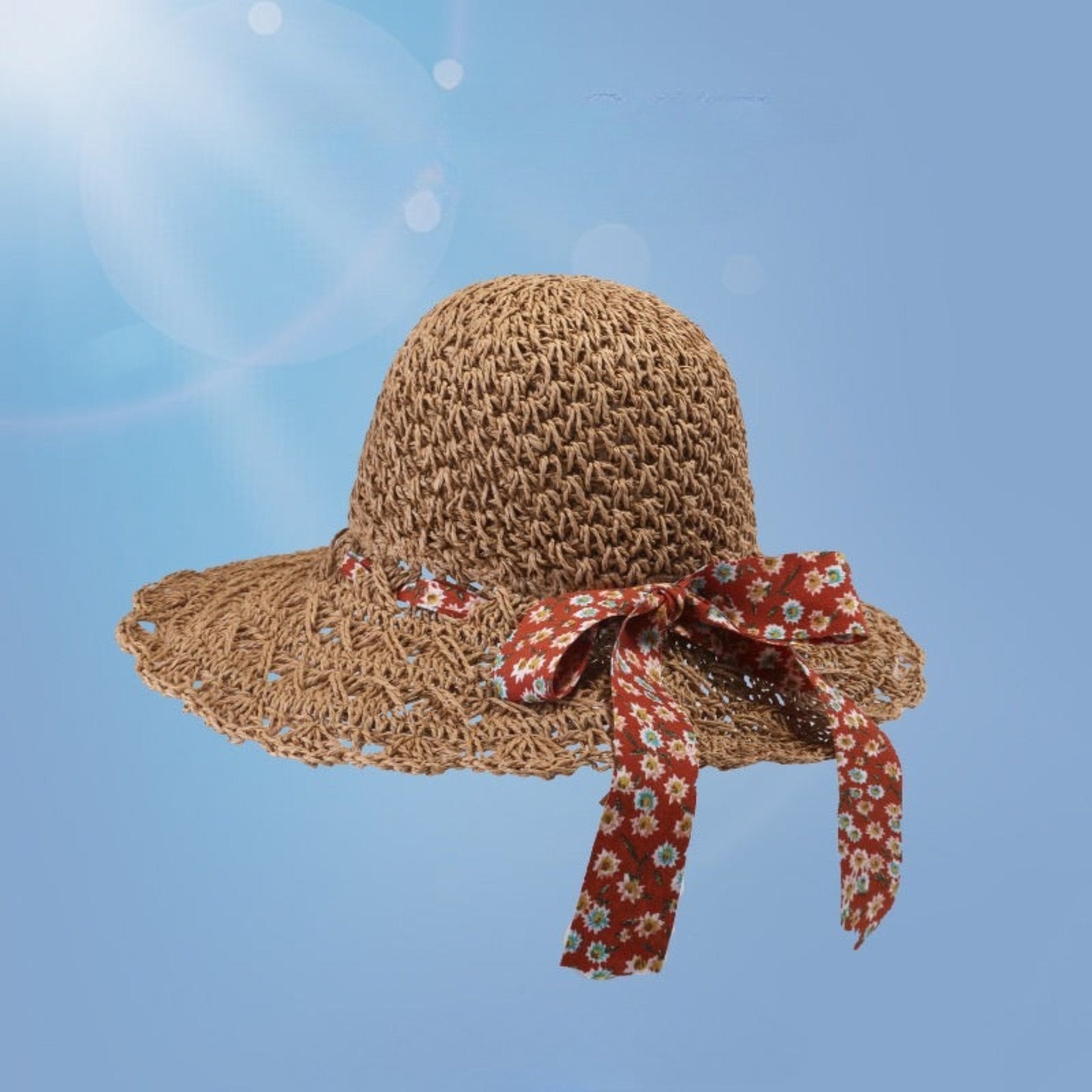 Brown woven straw sun hat with a red floral bow, wide brim, and breathable open-weave design, set against a blue sky background.