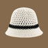 A white straw bucket hat with a black stripe across the middle and an airy open-weave design, perfect for sunny day outings.