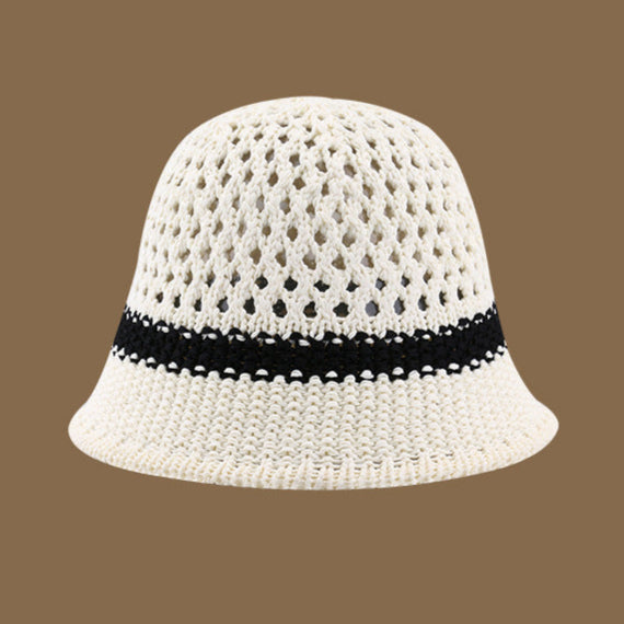 A white straw bucket hat with a black stripe across the middle and an airy open-weave design, perfect for sunny day outings.