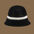 A black straw bucket hat featuring a contrasting white stripe and an open-weave top, offering a modern and elegant summer look.