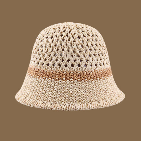 A beige straw bucket hat with a light brown stripe and an open-weave pattern on top, blending style and sun protection.
