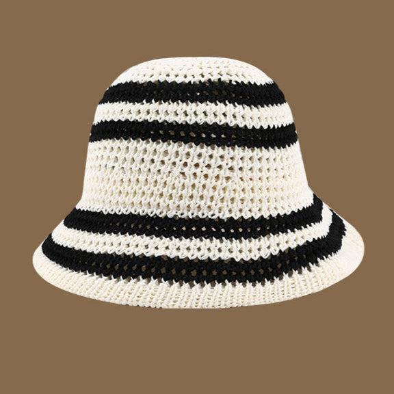 A white crochet bucket hat with black stripes, featuring a lightweight, breathable weave perfect for beach days and vacations.