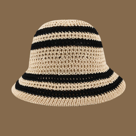 A beige crochet bucket hat with black stripes, designed with a soft brim and an airy woven pattern for a relaxed summer vibe.