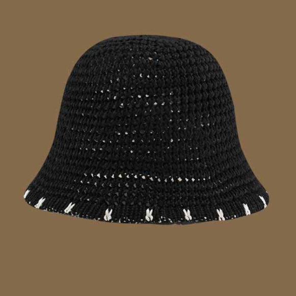  A black straw bucket hat with white contrast trim along the brim, combining a breathable woven design with a bold, elegant touch.