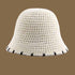 A white crochet-style straw bucket hat with a black-trimmed brim, offering a lightweight and chic sun protection option.