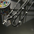 Black beaded cross necklaces with cross pendants on a dark surface