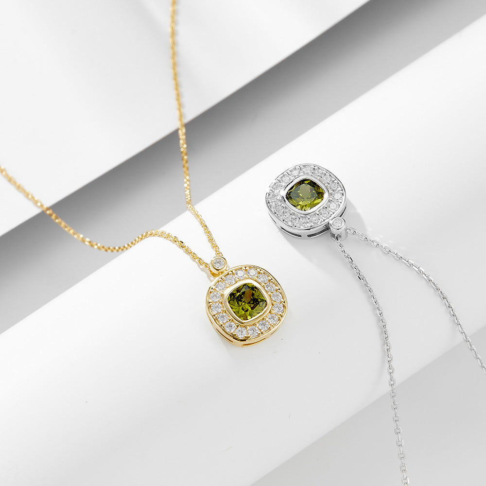 Gold and silver necklaces with matching green CZ pendants and white CZ halos displayed on white surface.