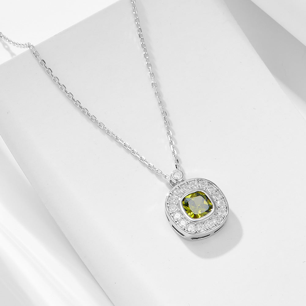Silver necklace with green cushion-cut CZ pendant and white CZ halo shown on flat white background.