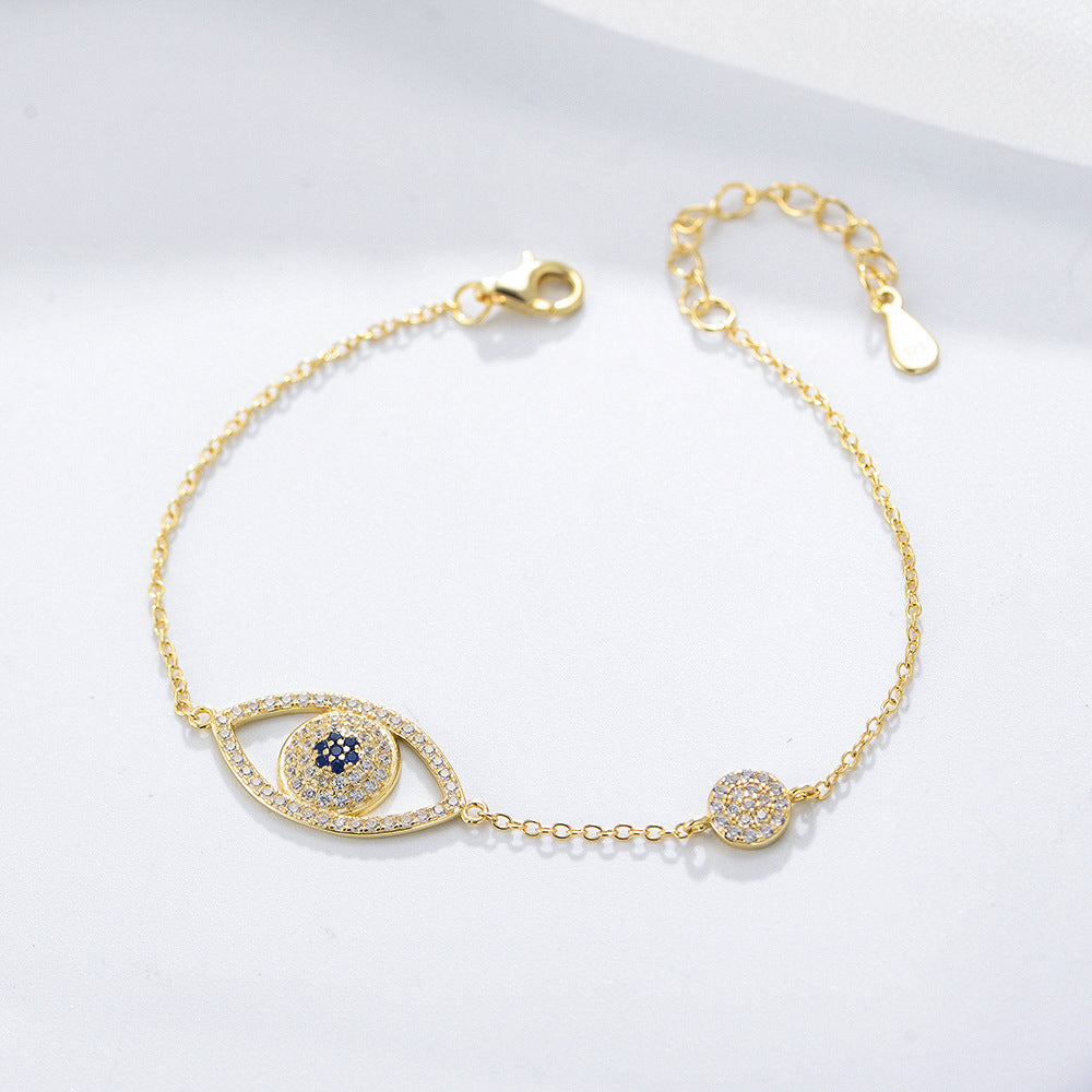 Gold evil eye bracelet with blue and clear CZ stones on a fine chain.