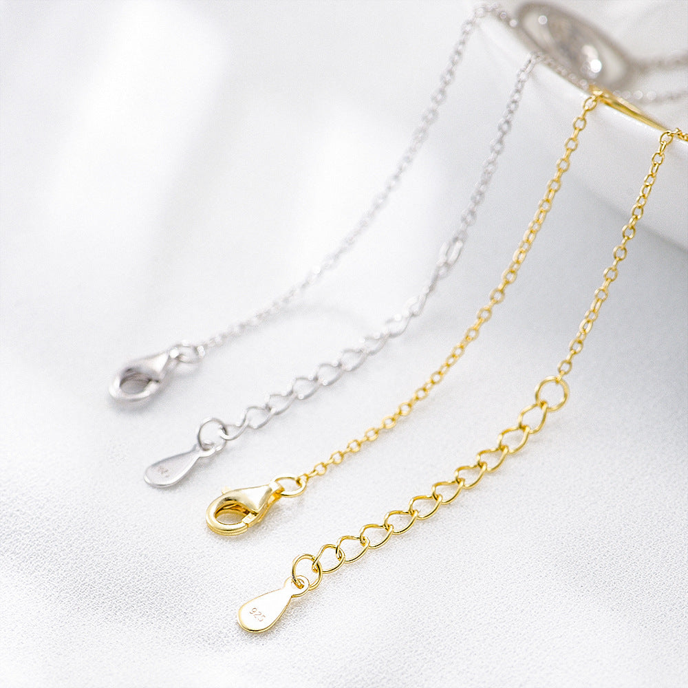 Close-up of silver and gold lobster clasps and extension chains marked “925”.