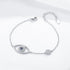 Silver evil eye bracelet with blue and clear CZ stones on white background.