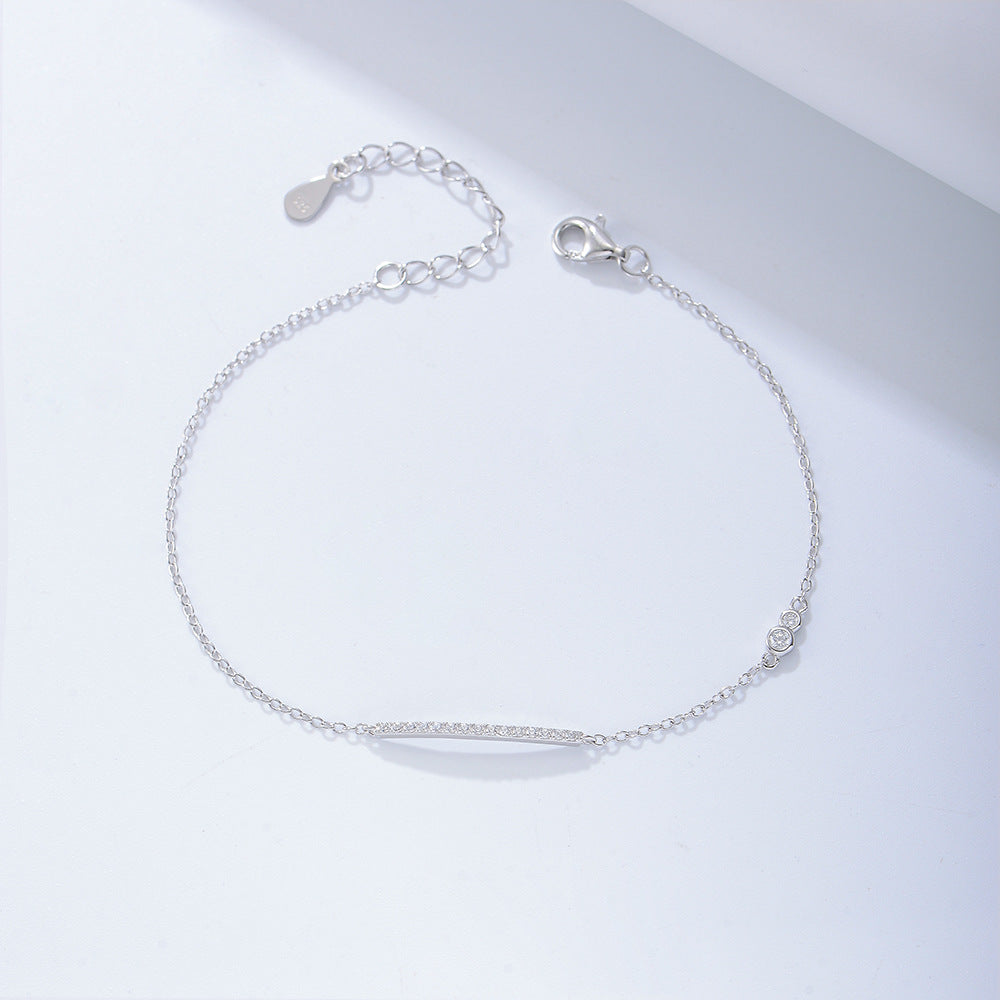 Silver bar bracelet with CZ accents displayed in a flat lay.