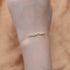 Gold MAMA charm bracelet worn on wrist.