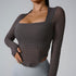 Side view of woman in charcoal textured square-neck bodysuit with long sleeves paired with light gray leggings