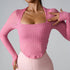 Woman wearing pink textured square-neck top with long sleeves matched with light pink high-waisted leggings