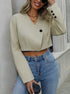 Women's cropped blazer in beige styled with high-waist jeans and layered necklaces