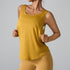 A woman is wearing a mustard yellow sleeveless tank top with a scoop neckline and matching leggings, posing against a neutral backdrop