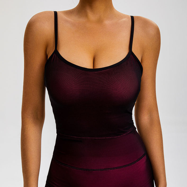 A woman is modeling a burgundy seamless cami top with black trim and matching compression leggings against neutral background