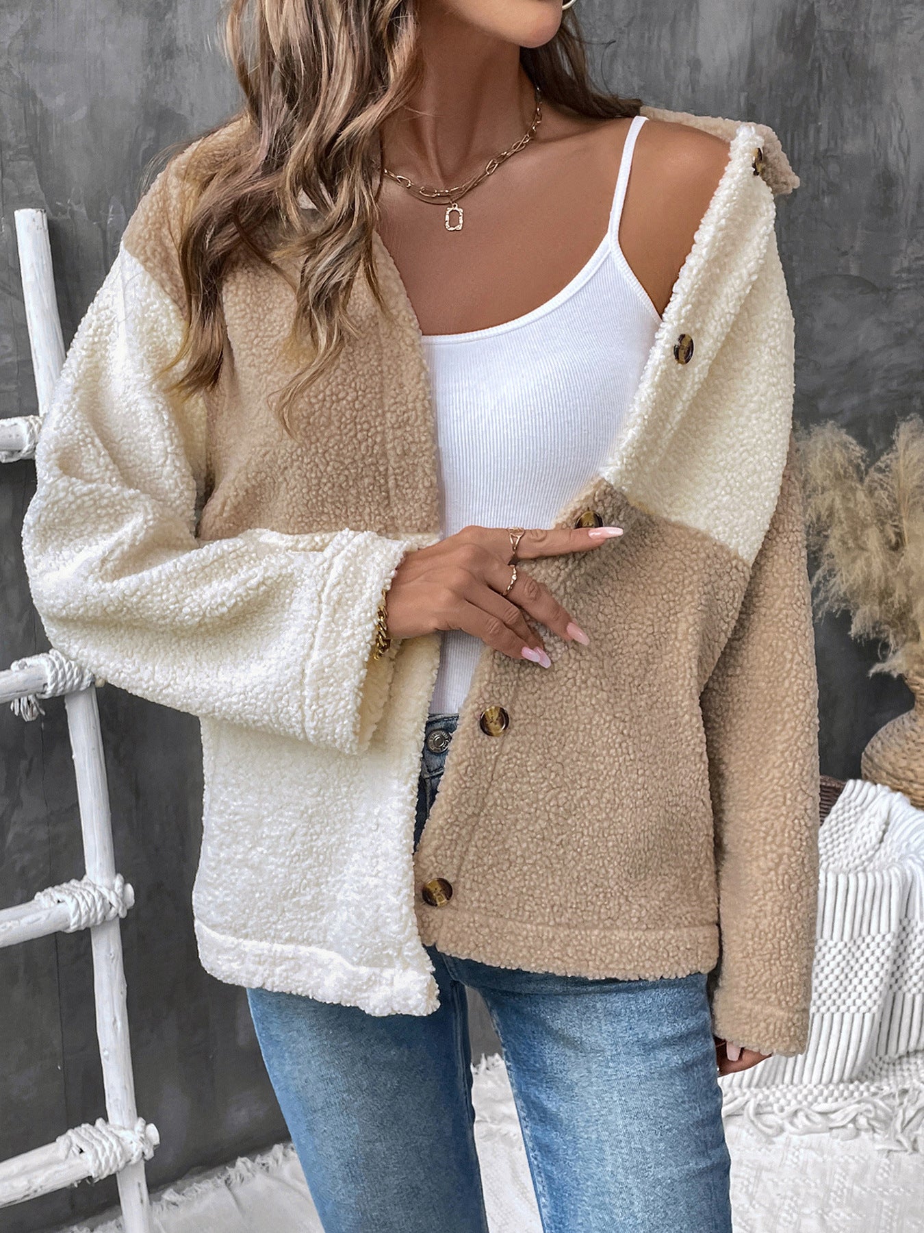 Two-tone beige and cream sherpa jacket with button front over white tank top and jeans