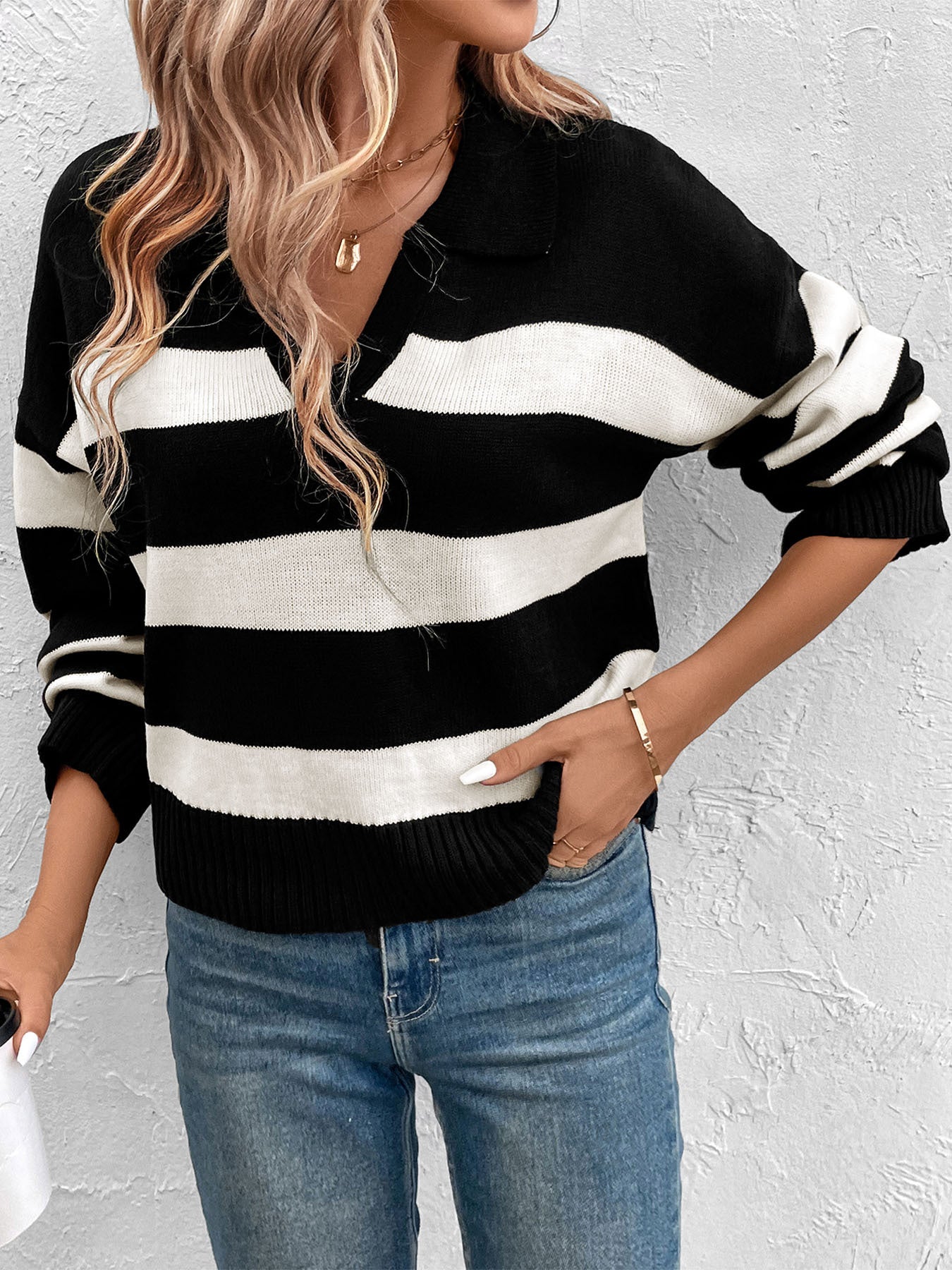 Striped black and white collared sweater paired with jeans and gold necklaces